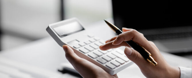Businessman is using a calculator to calculate company financial