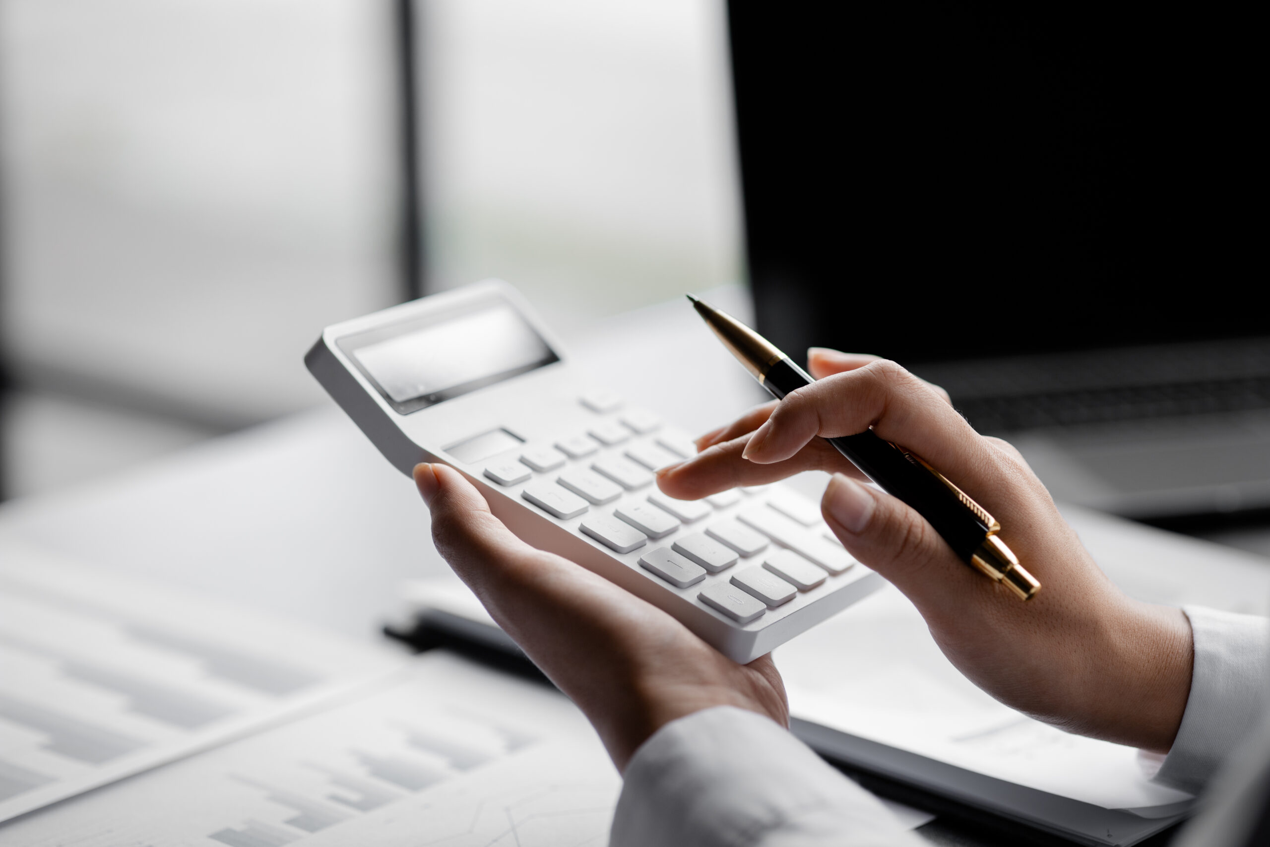 Businessman is using a calculator to calculate company financial